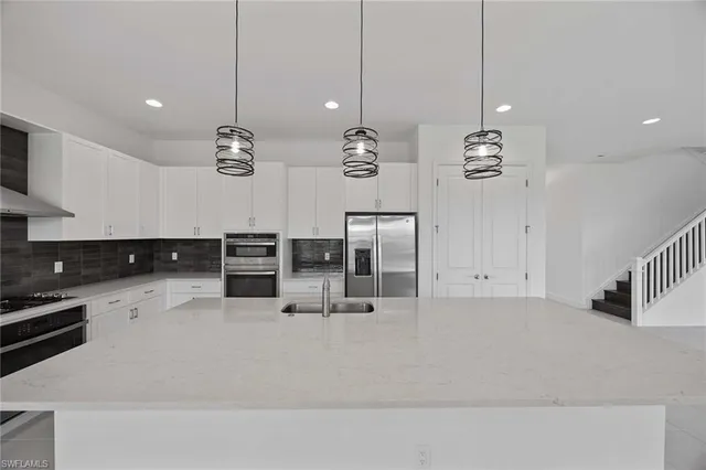 a kitchen with stainless steel appliances kitchen island granite countertop a table and chairs in it