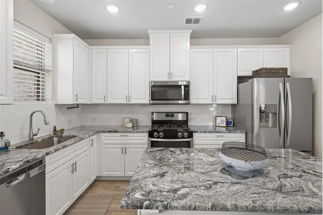a kitchen with a sink a stove a refrigerator and cabinets