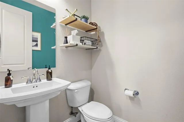 a bathroom with a sink a toilet and mirror