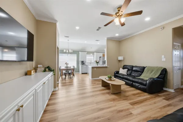 a living room with furniture and a wooden floor