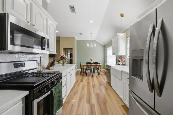 a kitchen with stainless steel appliances a stove a sink and a refrigerator