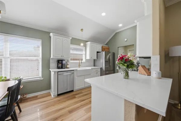 a kitchen with a sink cabinets and wooden floor