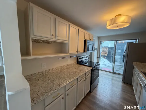 a kitchen with stainless steel appliances granite countertop a stove a sink and a refrigerator