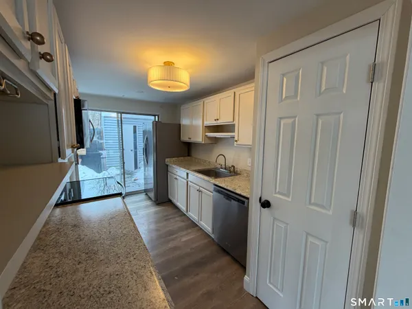 a kitchen with stainless steel appliances granite countertop a refrigerator and a sink