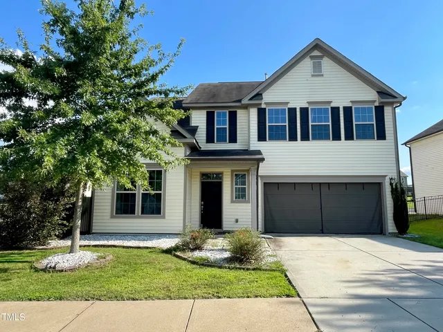 a front view of a house with a yard and garage