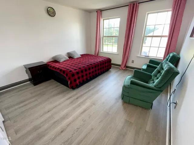 a bedroom with a bed and a lamp on dresser