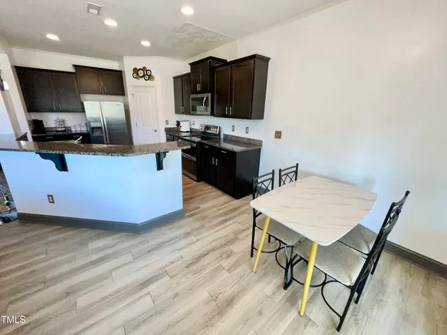 a kitchen with stainless steel appliances granite countertop a stove a sink dishwasher and a refrigerator