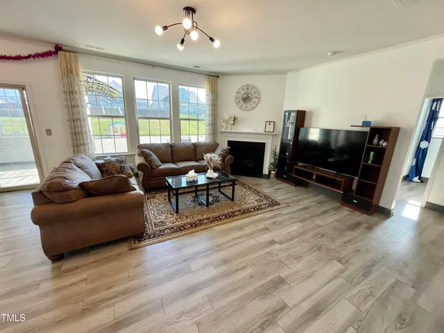 a living room with furniture a flat screen tv and a large window