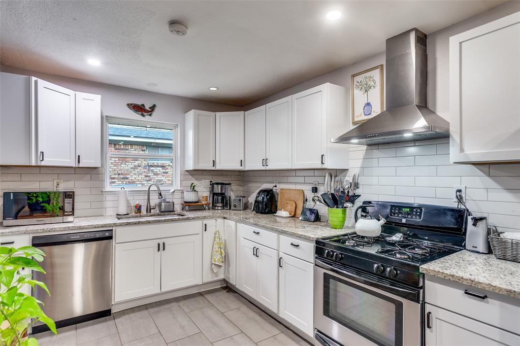 6921 Valhalla Road Fort Worth, TX 76116 - Photo 13 of 25 Kitchen with stainless steel appliances, wall chimney exhaust hood, white cabinets, light stone counters, and recessed lighting