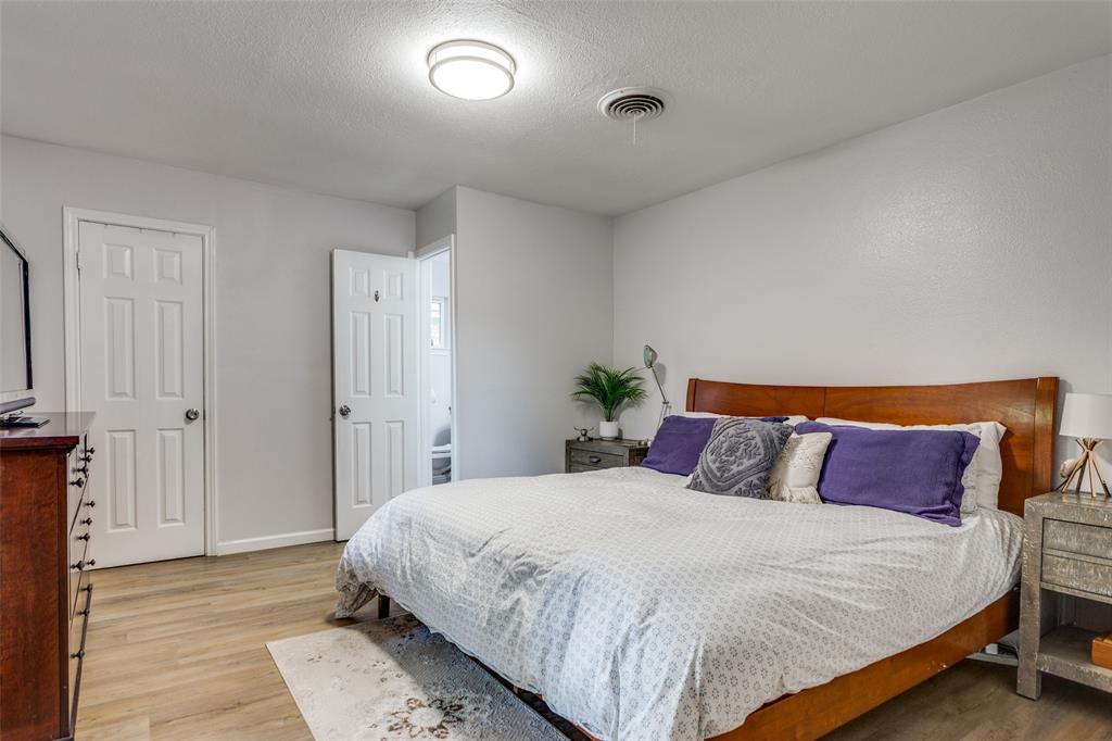 6921 Valhalla Road Fort Worth, TX 76116 - Photo 16 of 25 Bedroom featuring light wood-type flooring and a textured ceiling
