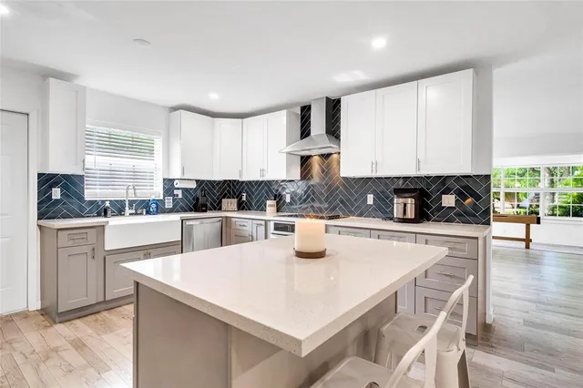 a kitchen with stainless steel appliances granite countertop a stove a sink a refrigerator a microwave and white cabinets