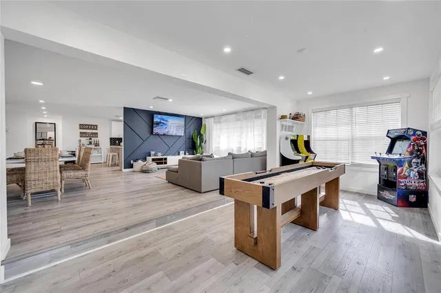 a living room with furniture a table and kitchen view
