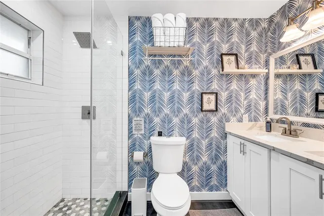 a white toilet sitting next to a bathroom sink
