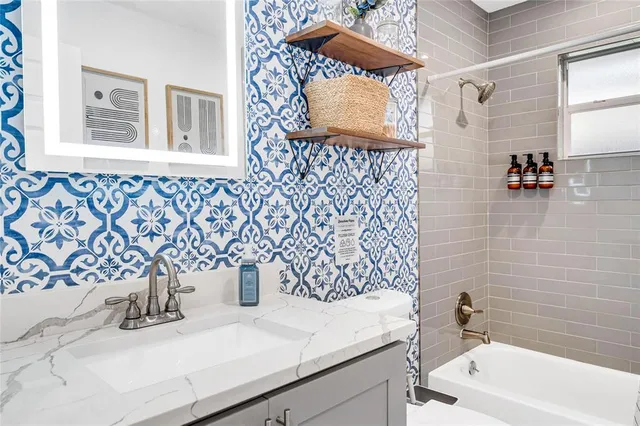 a bathroom with a bathtub sink and mirror