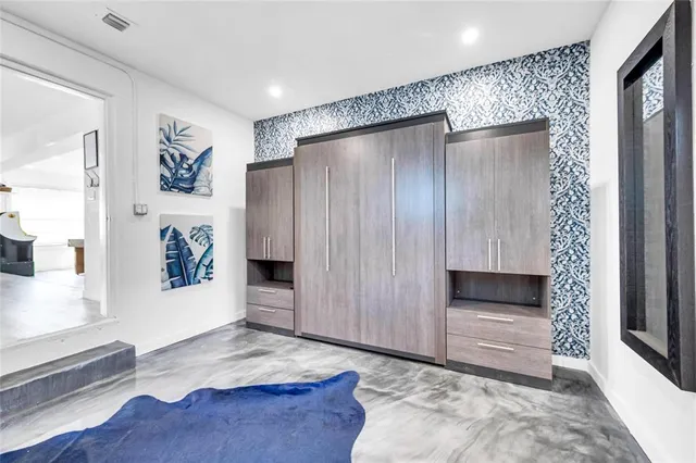a view of a hallway with wooden floor and cabinet
