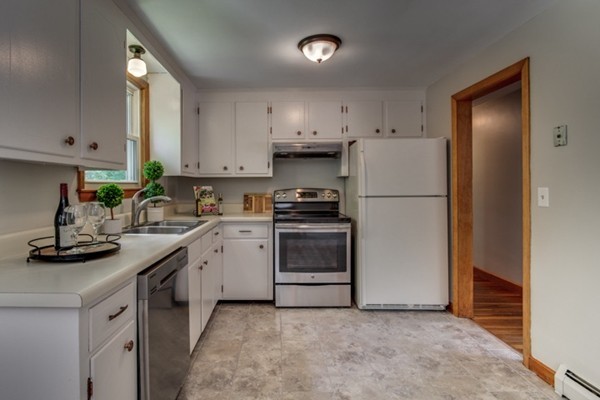 6 Hanson Road Wilmington, MA 01887 - Photo 11 of 29 a kitchen with a sink white cabinets and white appliances