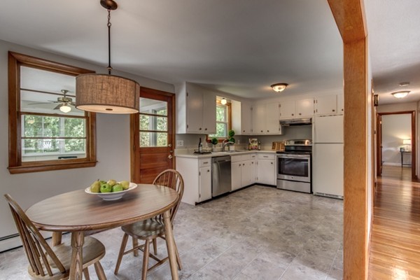 6 Hanson Road Wilmington, MA 01887 - Photo 15 of 29 a kitchen with white cabinets stainless steel appliances and a dining table