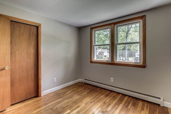 6 Hanson Road Wilmington, MA 01887 - Photo 20 of 29 a view of an empty room with wooden floor and a window