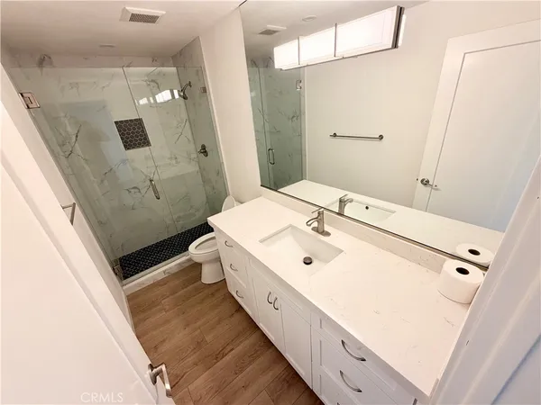 a bathroom with a sink a toilet and shower
