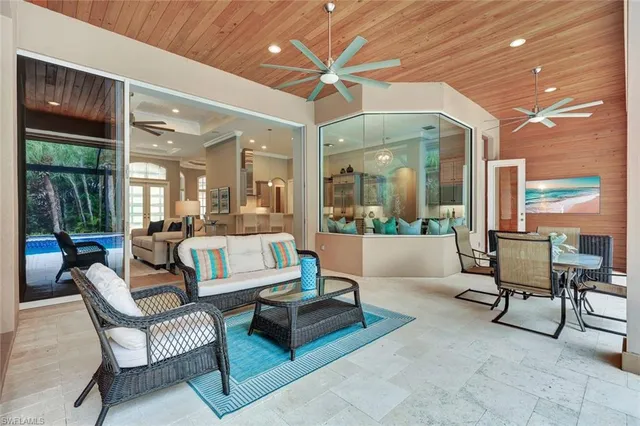 a living room with furniture a large window and a chandelier