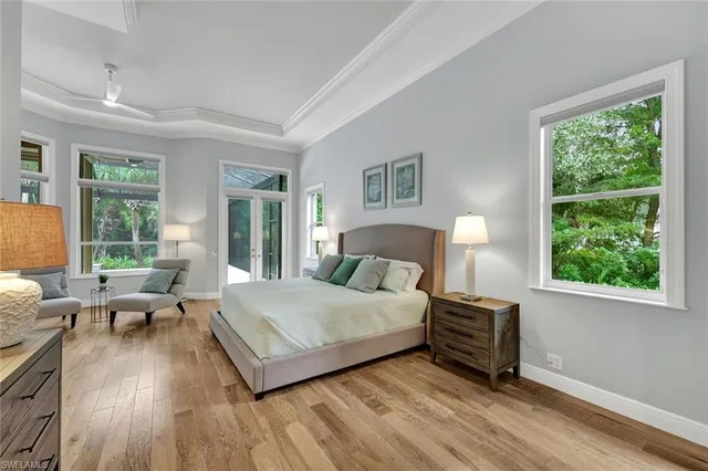 a bedroom with a bed and large windows