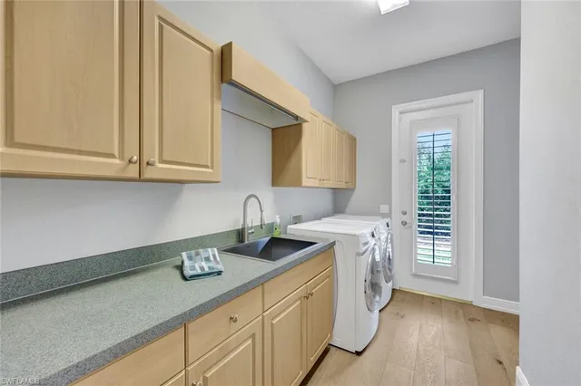 a utility room with cabinets washer and dryer