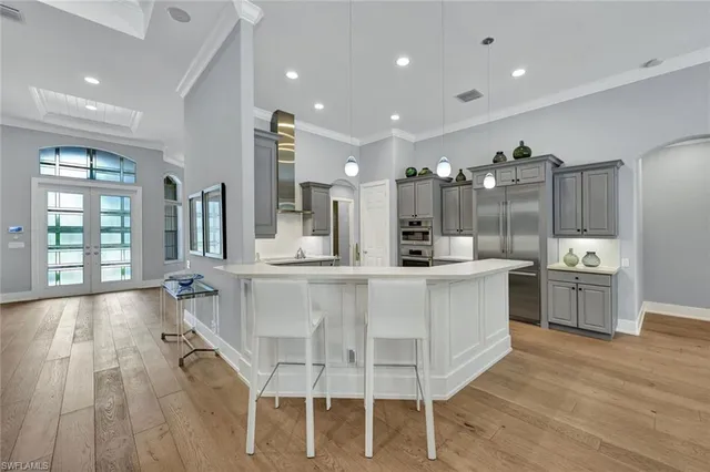 a large white kitchen with a large window and stainless steel appliances