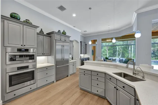 a kitchen with kitchen island granite countertop a sink stainless steel appliances and cabinets