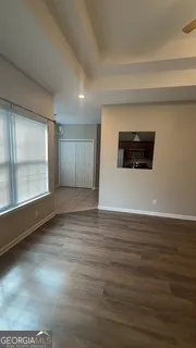 a view of empty room with wooden floor and window