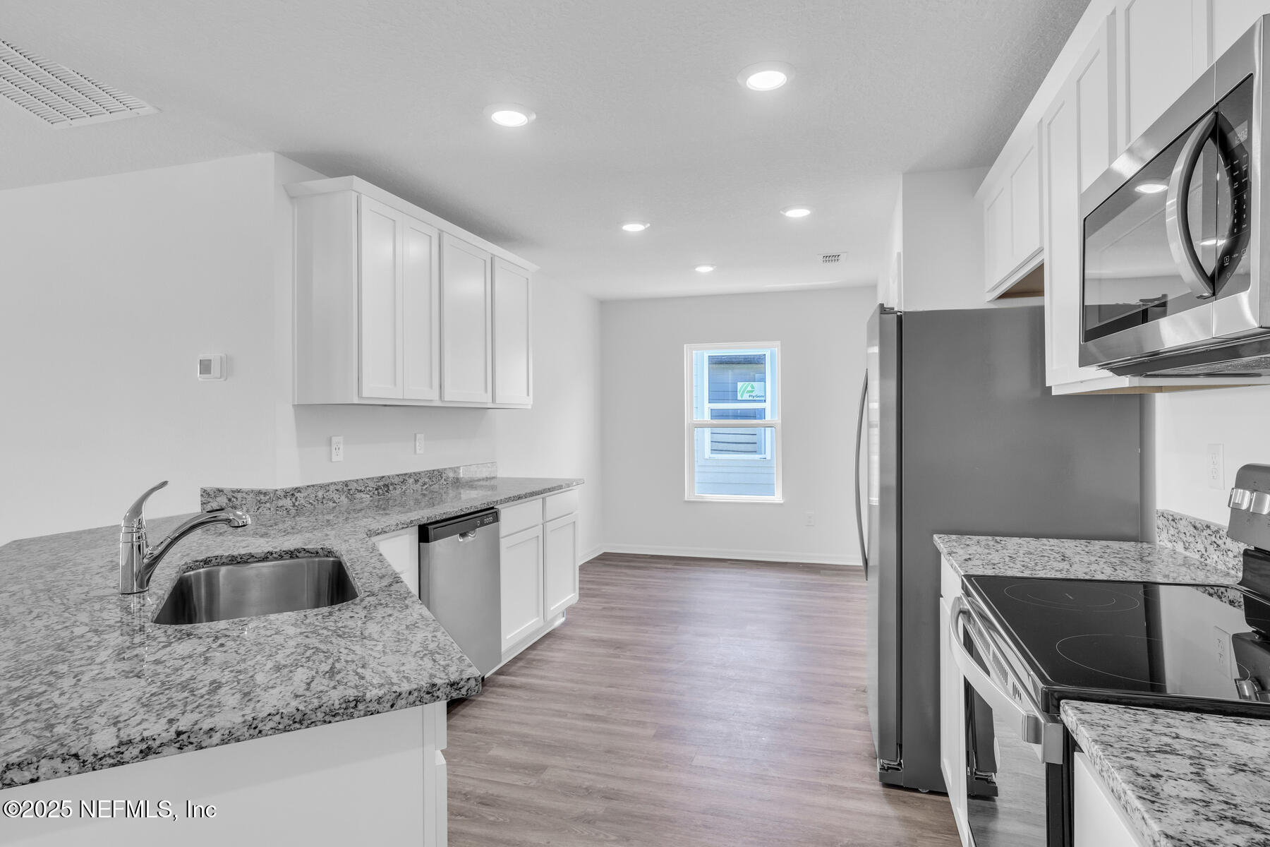 37151 Whippoorwill Court Hilliard, FL 32046 - Photo 5 of 19 a kitchen with stainless steel appliances granite countertop a sink stove and refrigerator