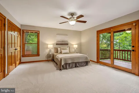 a view of a hallway with wooden floor and a bathroom