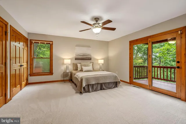 a view of a hallway with wooden floor and a bathroom