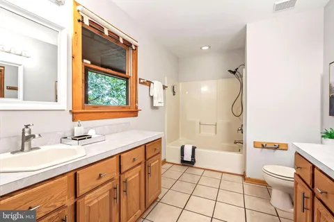 a living room with furniture a flat screen tv and a large window