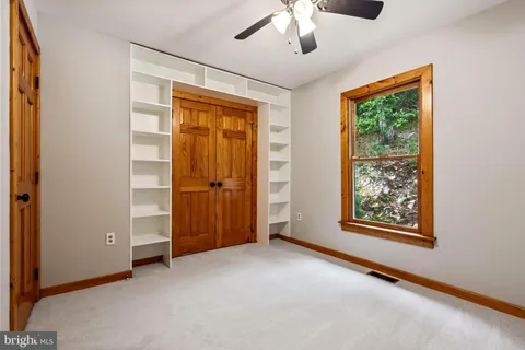 a balcony of a house with wooden floor outdoor seating and yard in the back