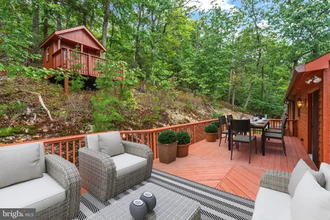 a balcony with wooden floor and yard in the back