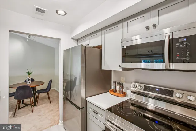 a kitchen with stainless steel appliances a stove a refrigerator and a microwave
