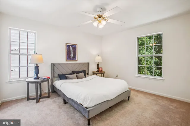 a large bedroom with a bed table and chair