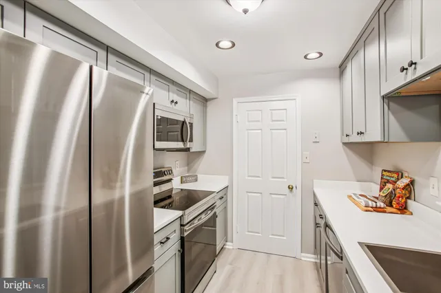 a kitchen with stainless steel appliances a refrigerator sink and stove