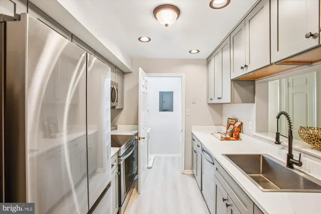 a kitchen with a sink a refrigerator a stove a microwave and cabinets