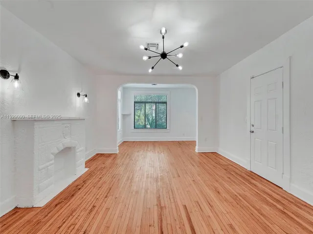 a view of an empty room and wooden floor