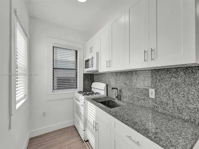 a kitchen with white cabinets and white appliances