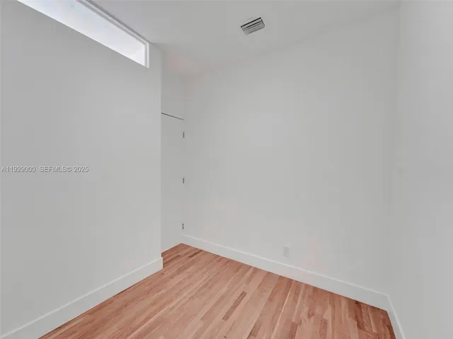 a view of an empty room with wooden floor