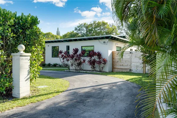 a front view of house with yard and trees in the background