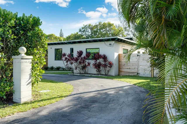 a front view of house with yard and trees in the background
