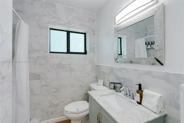 a bathroom with a sink a toilet and mirror