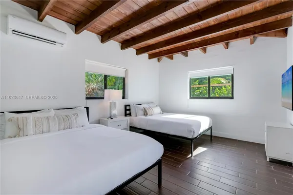 a bedroom with 2 bed and a window