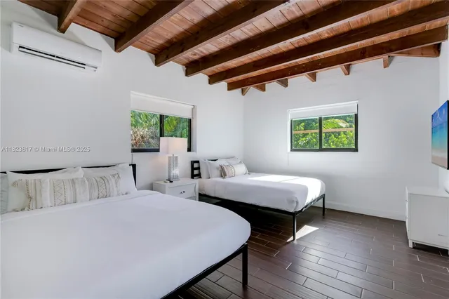 a bedroom with 2 bed and a window