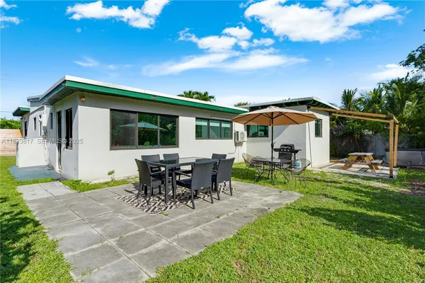 a view of a house with backyard porch and sitting area