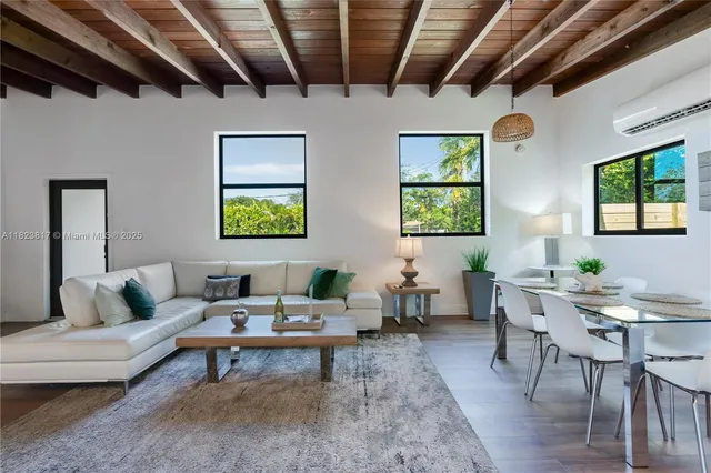 a living room with furniture a chandelier and a wooden floor