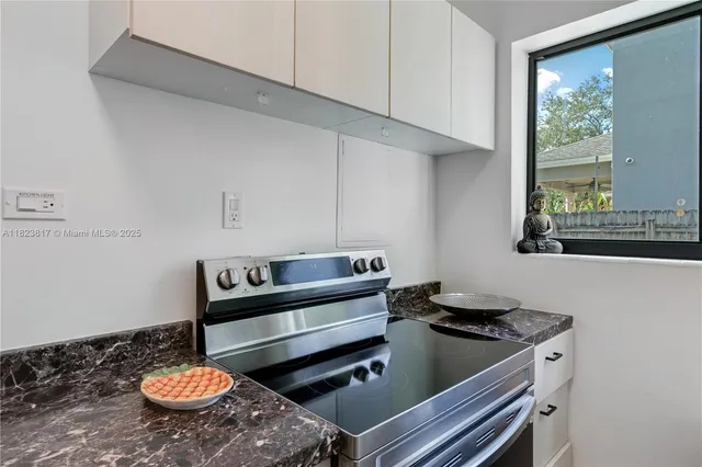 a kitchen with a stove and a window